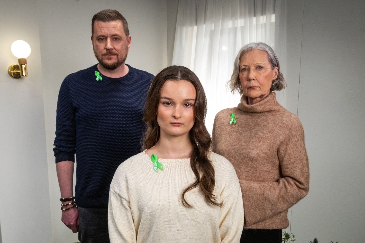 Kolme ihmistä seisoo ryhmänä Mielinauhat rinnassa