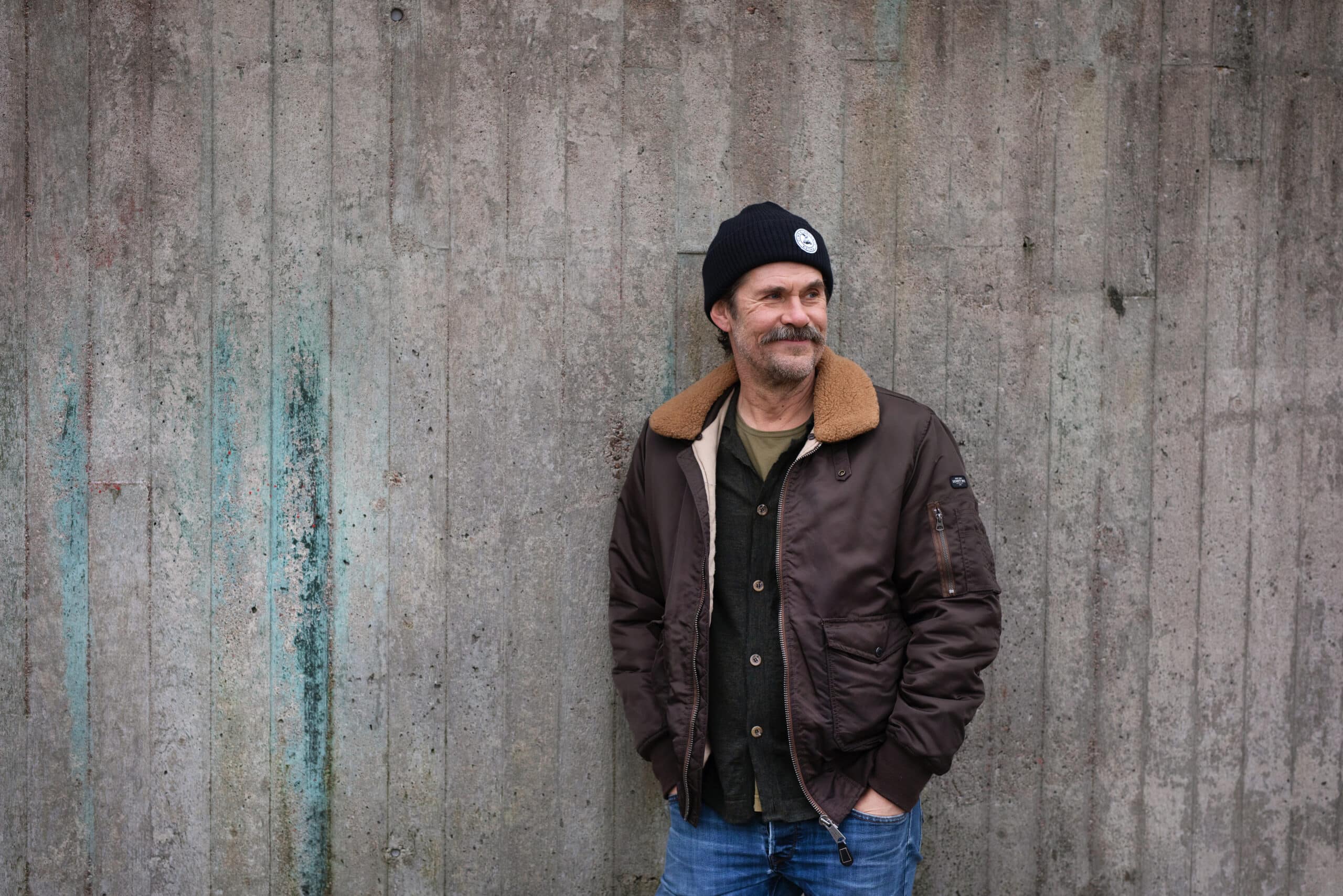 Tommi Korpela nojaa betoniseinään.