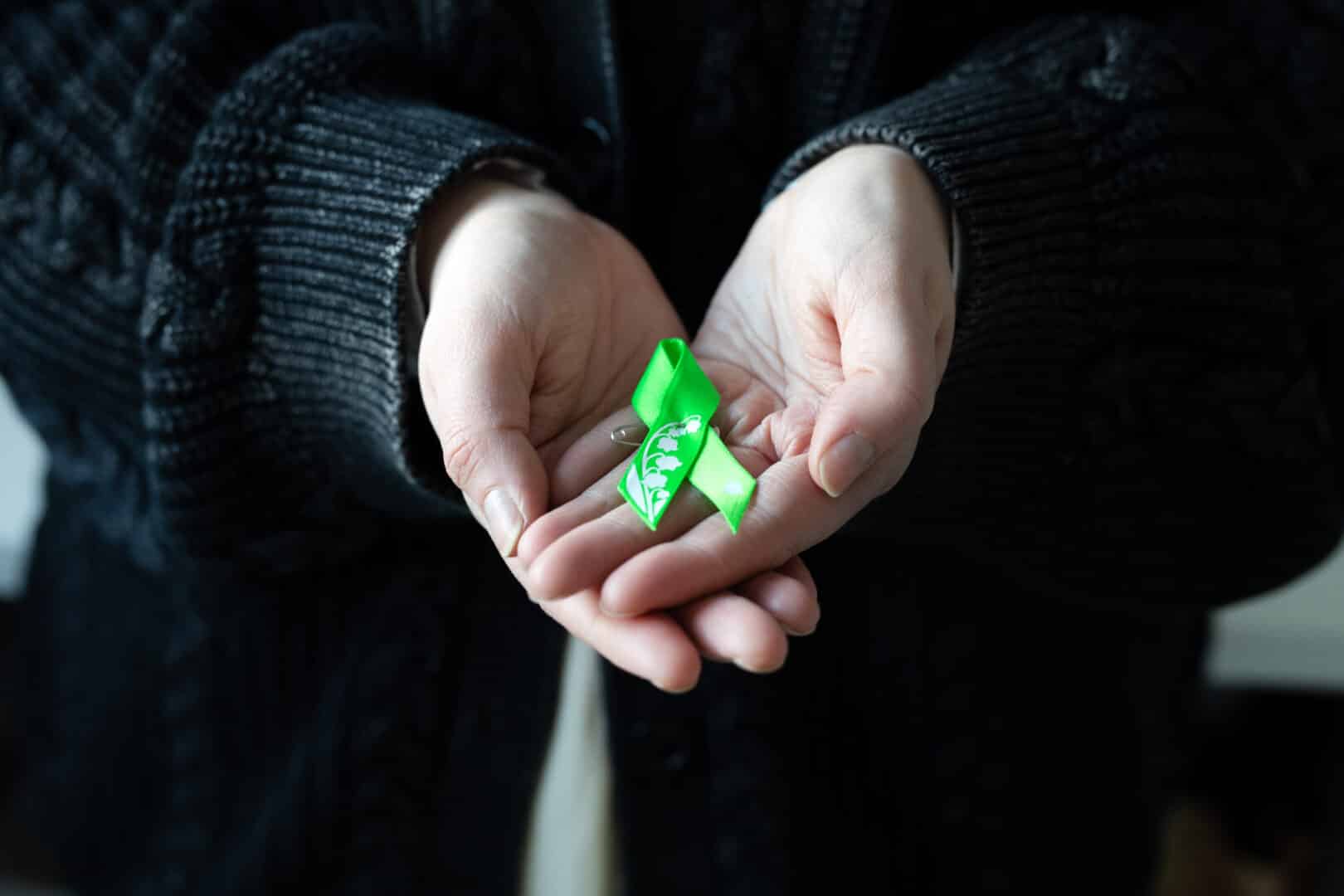 Nauhan suunnittelija pitelee käsissään Mielinauhaa 2026. Kädet muodostavat kuvassa sydämen kuvion.